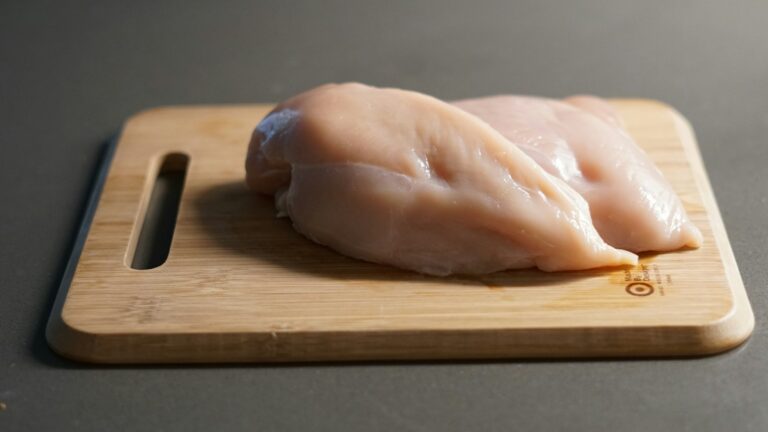 Hähnchen schnell auftauen – rohe Hähnchenbrust auf einem Holzbrett