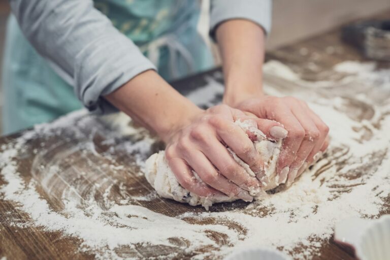 Trockenhefe umrechnen – Hefeteig wird auf einer bemehlten Arbeitsfläche geknetet