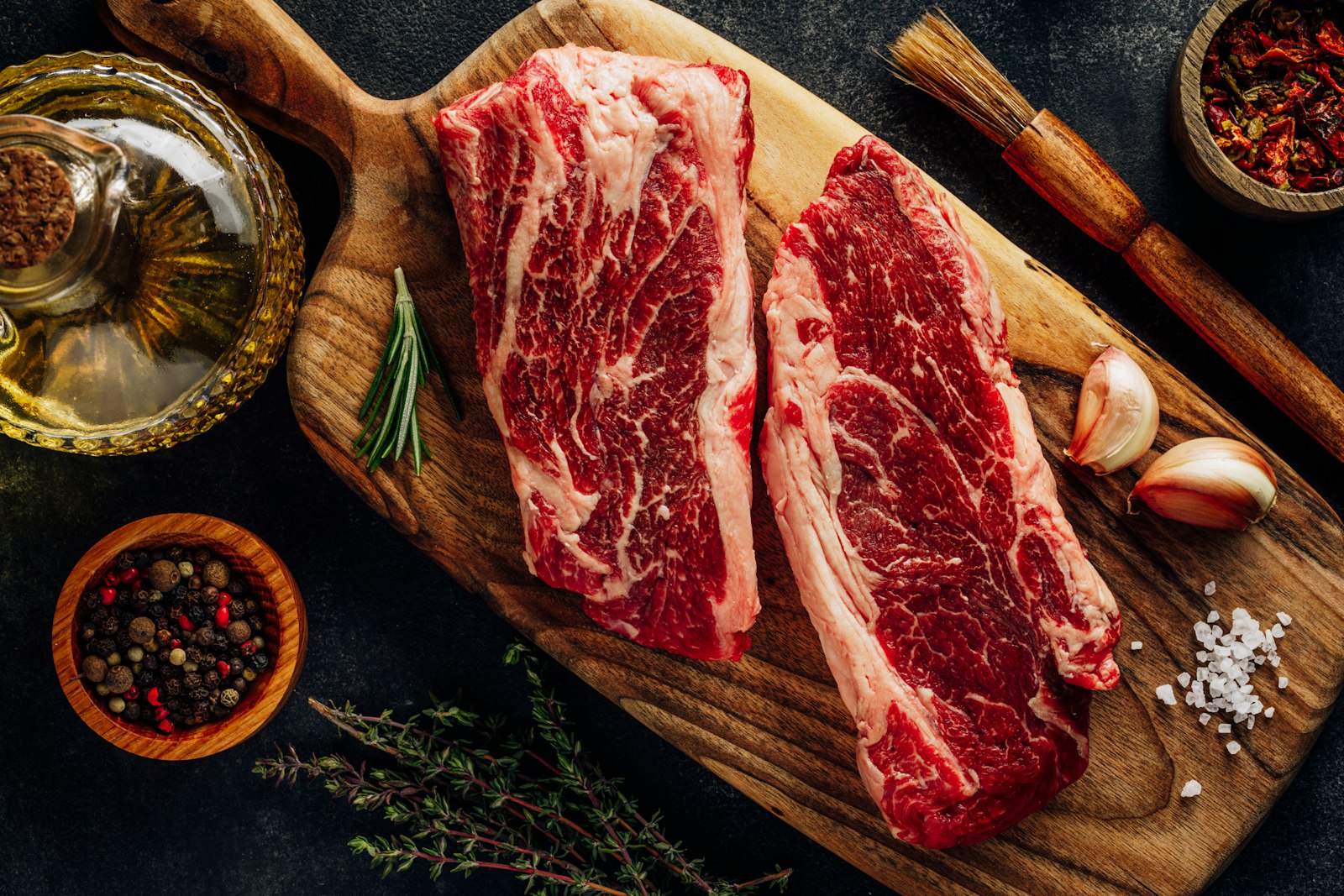 Wie lange marinieren – rohe Rindersteaks mit Öl, Pinsel und Gewürzen