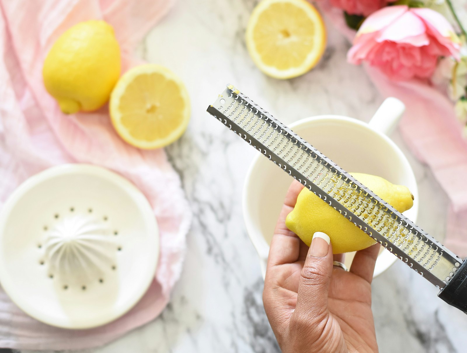 Zitronensaft einfrieren – Zitronenschale wird mit einer Reibe abgerieben